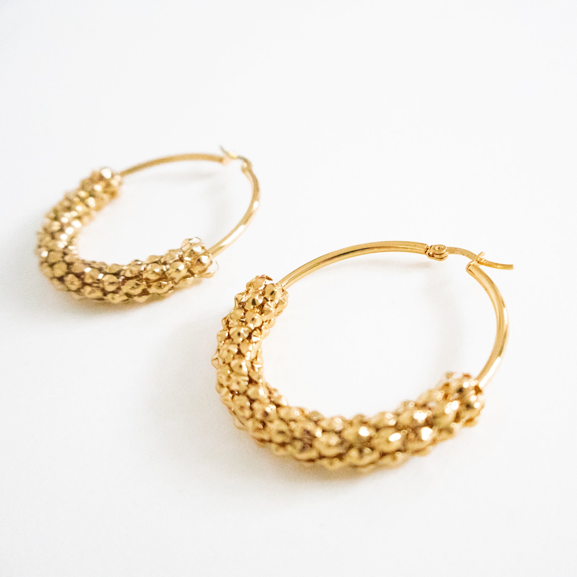 Gold hoop earrings on a white background