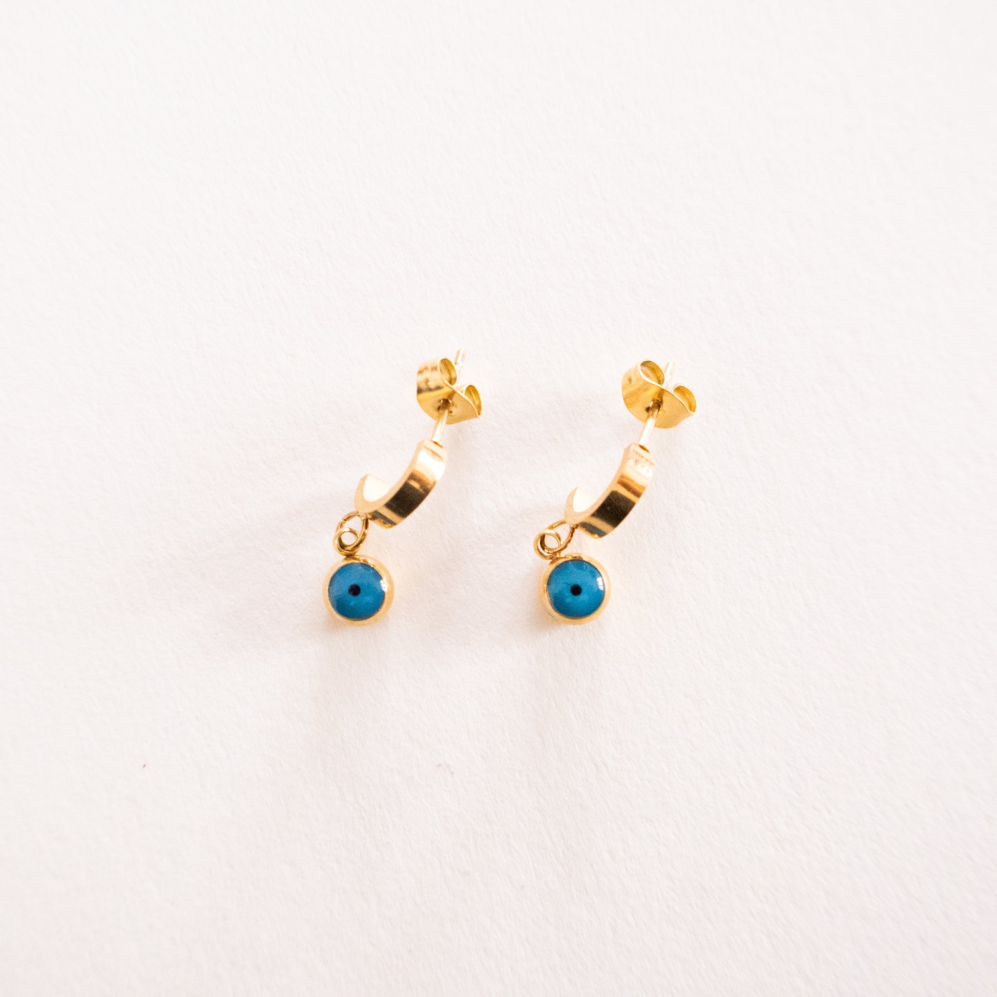 Gold hoop earrings with turquoise stones on a white background