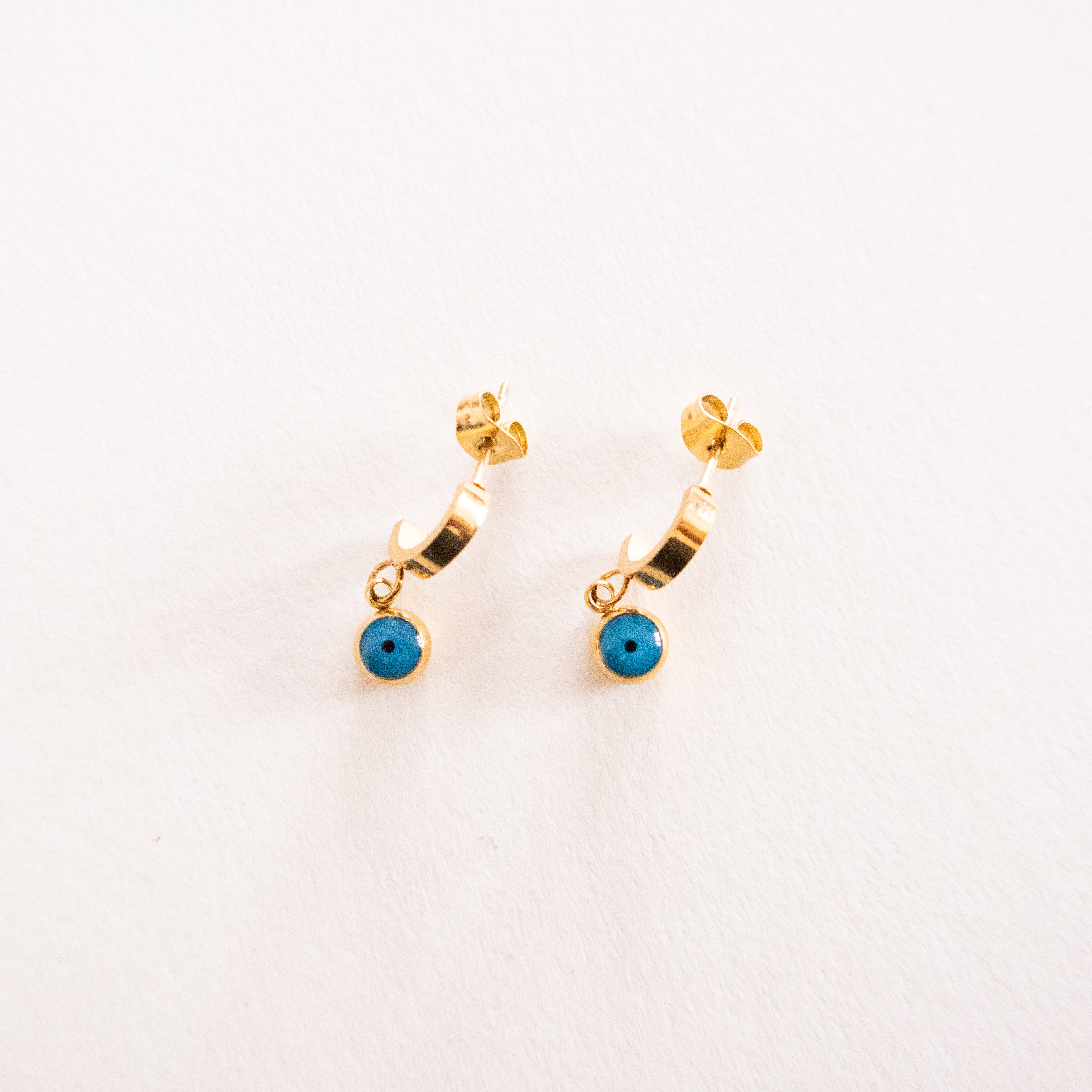 Gold hoop earrings with turquoise stones on a white background