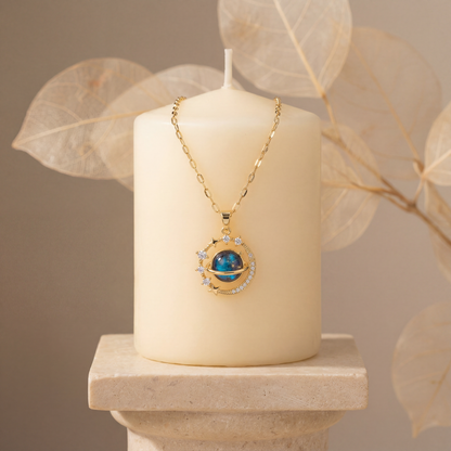 Gold necklace with a blue pendant on a white candle against a beige background