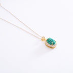 Gold necklace with a turquoise pendant on a white background