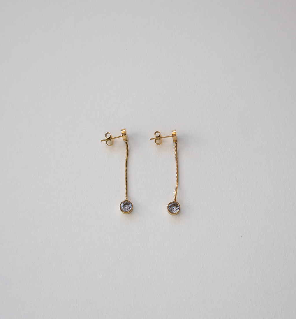 Brincos pendentes de corrente dourada em aço inoxidável com detalhes em cristal.