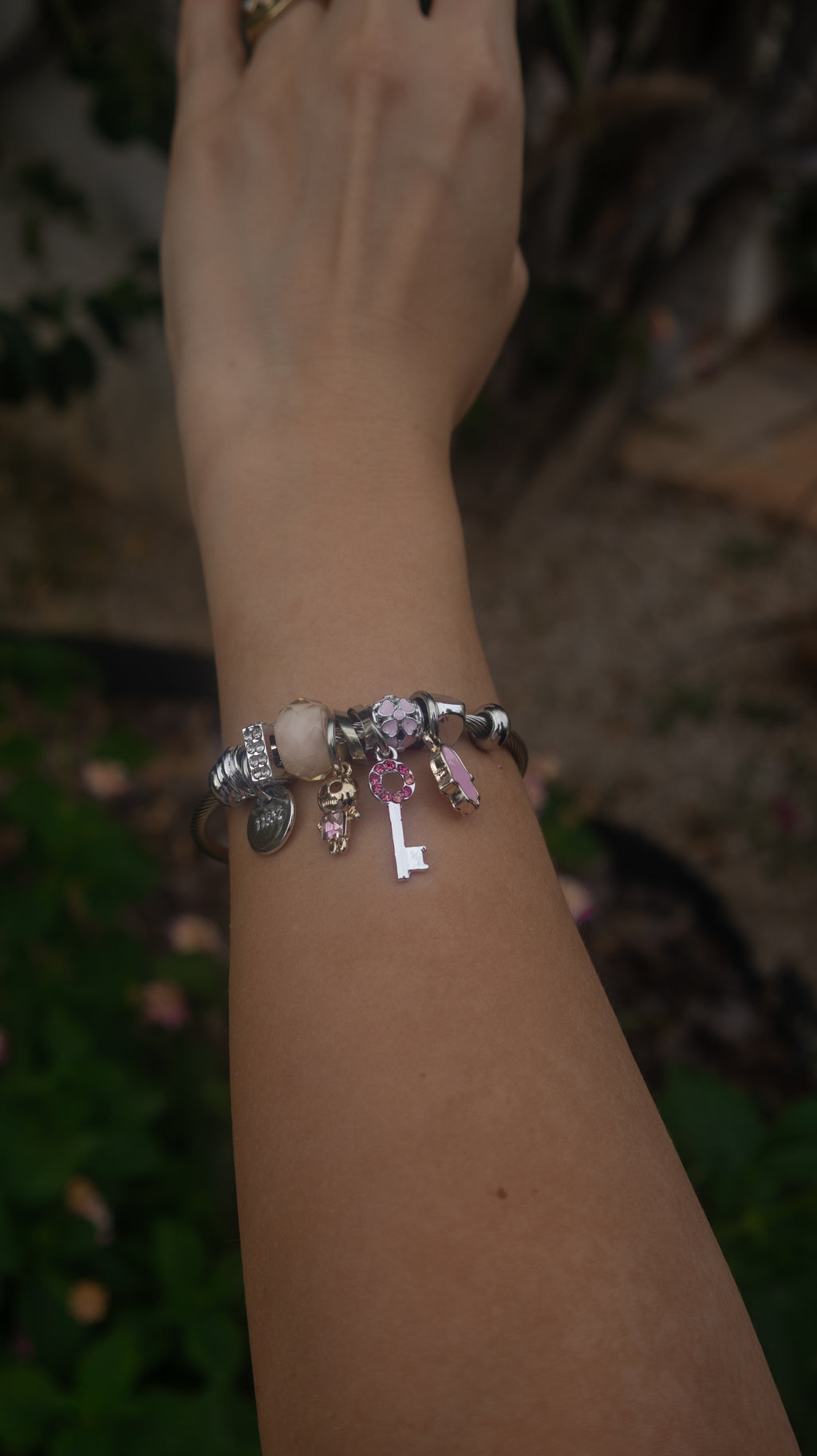 Pulseira com pendentes em aço inoxidável com detalhes em rosa