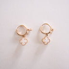 Pair of gold earrings with circular designs on a light background