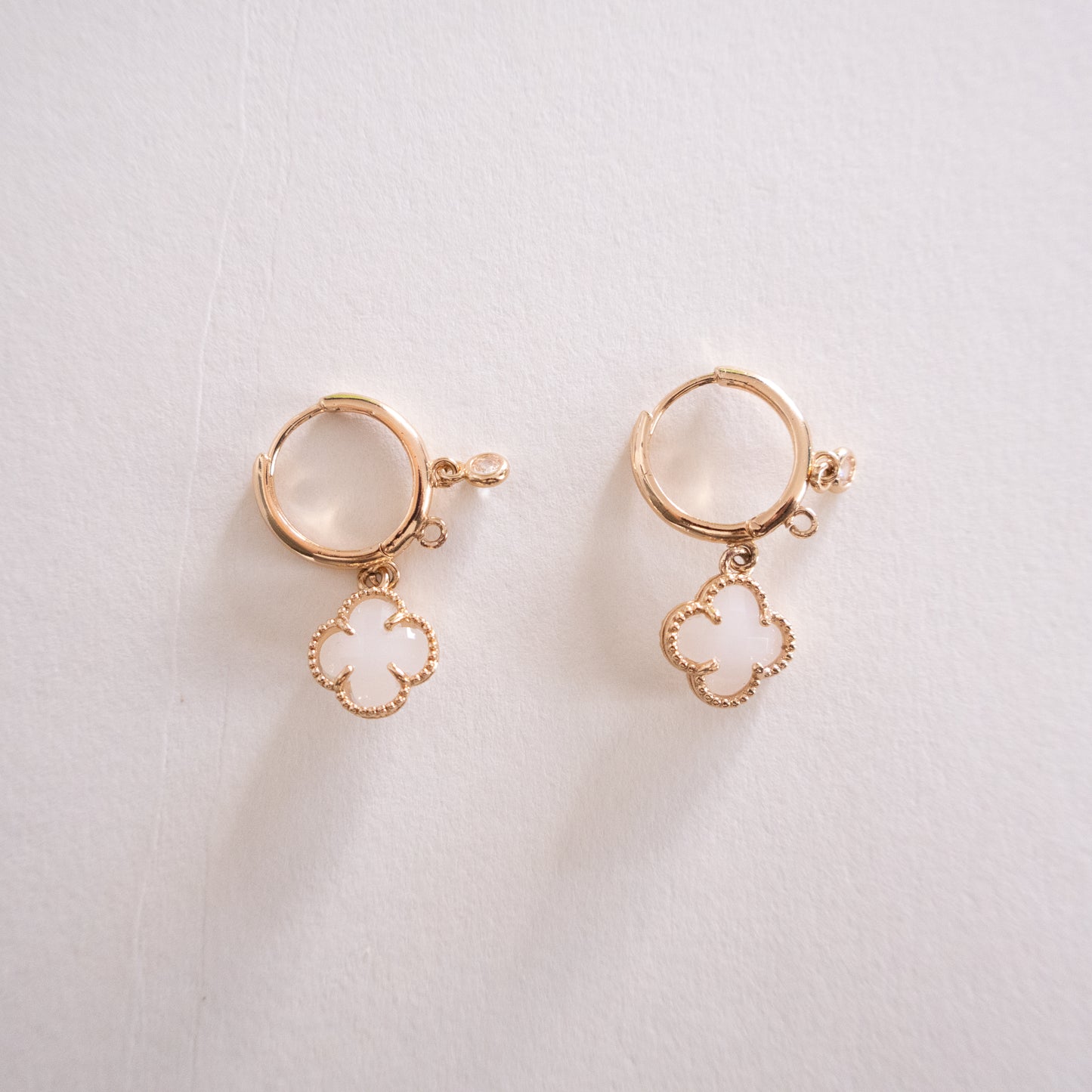 Pair of gold earrings with circular designs on a light background