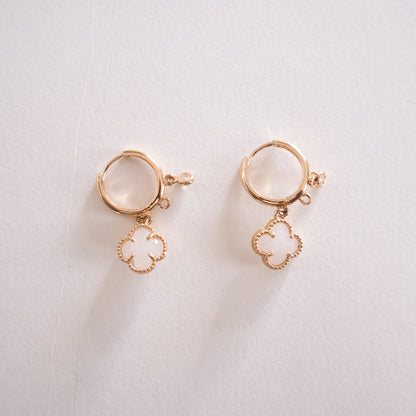 Pair of gold earrings with circular designs on a light background