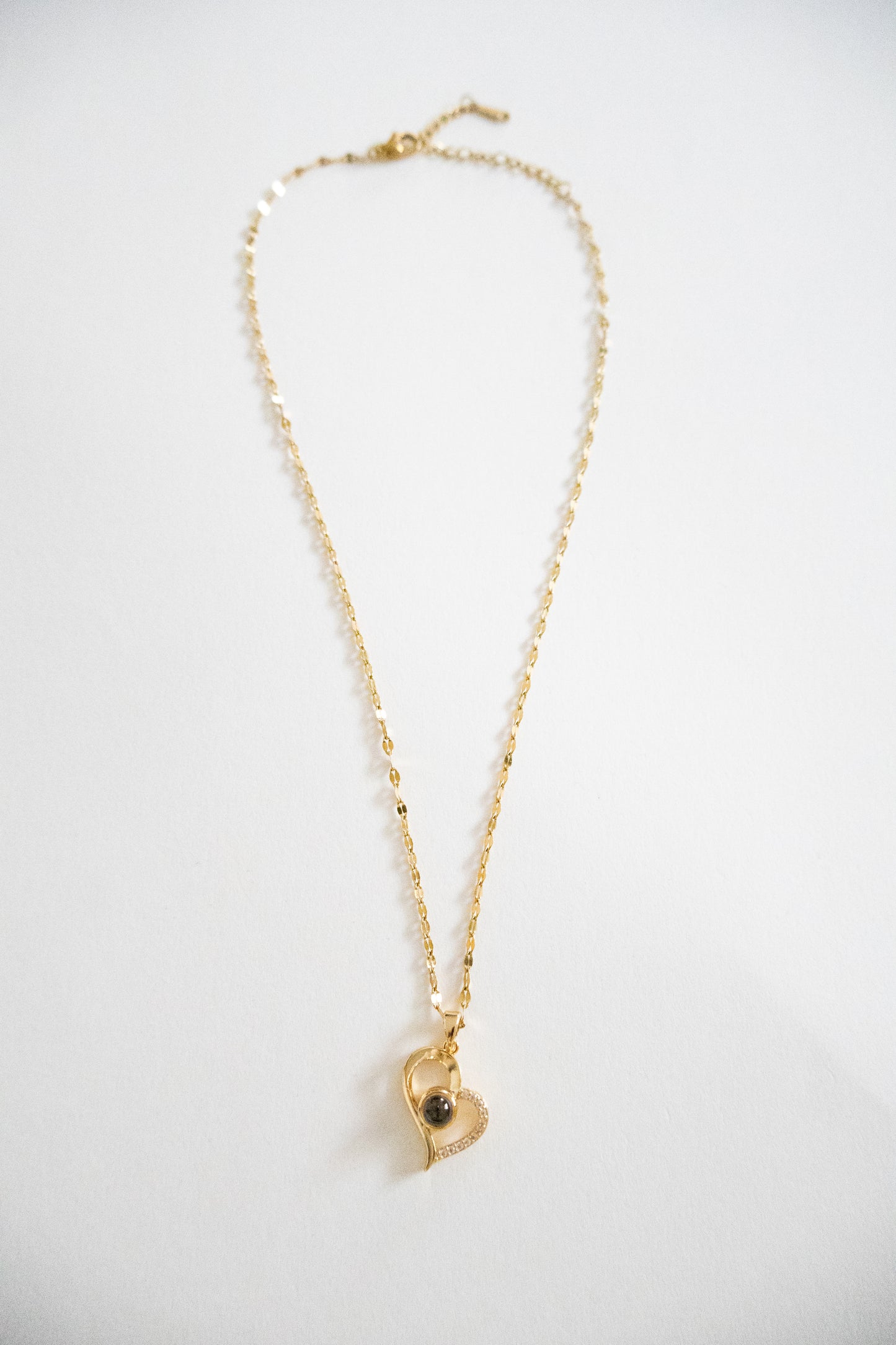 Collar de corazón de piedra reactiva a la luz dorada 