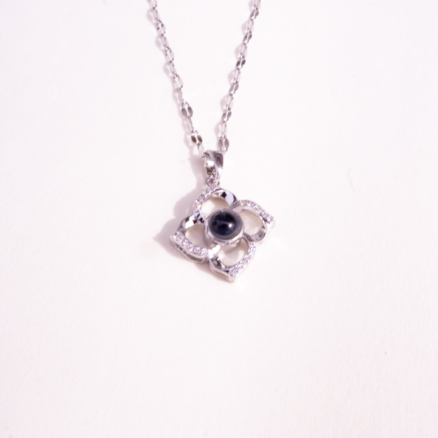 Collar con colgante de trébol de plata que reacciona a la luz