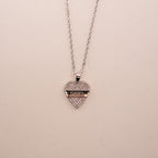 Gold necklace with a green gemstone pendant on a white background