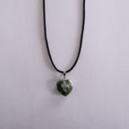 Silver necklace with a key pendant on a light pink background