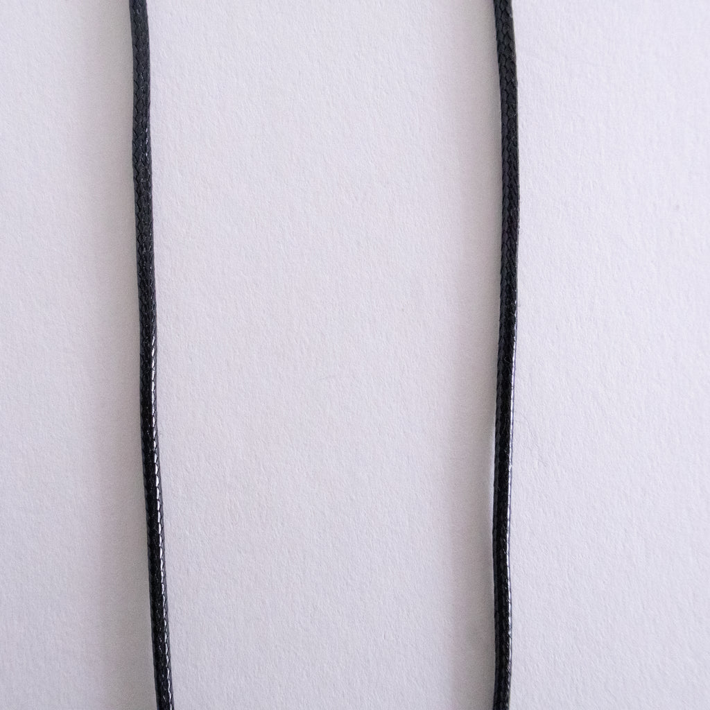 Close-up of a white fabric with black piping on a white background