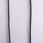 Close-up of a white fabric with black piping on a white background