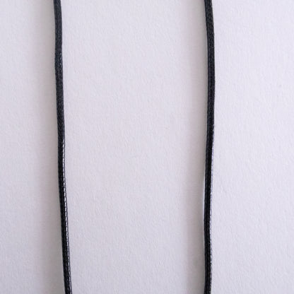 Close-up of a white fabric with black piping on a white background