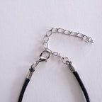 Silver necklace with a heart-shaped pendant on a beige background