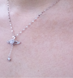 Necklace with a small pendant on a person's neck against a light background