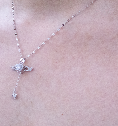 Necklace with a small pendant on a person's neck against a light background