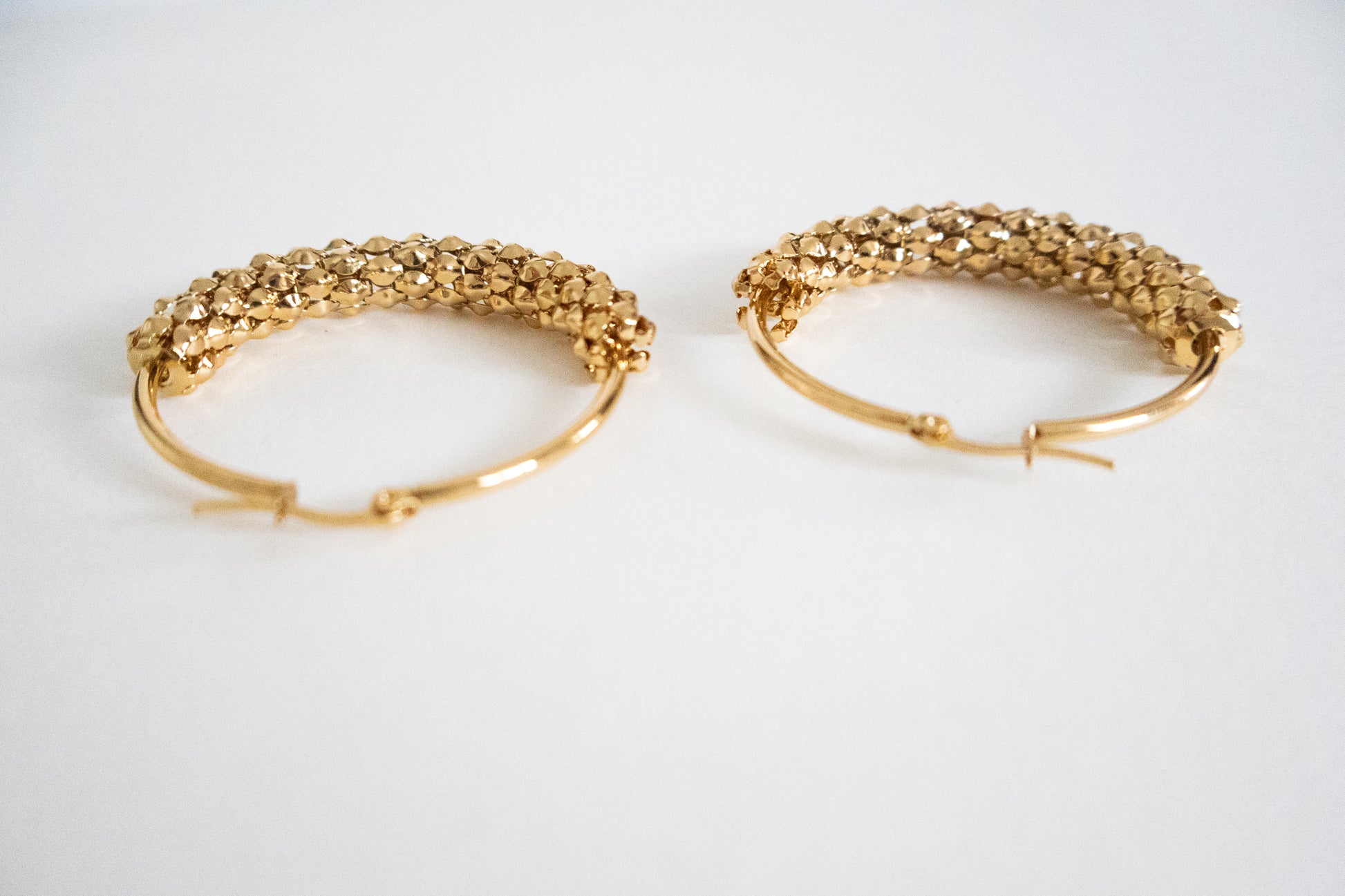 Pair of gold hoop earrings on a white background