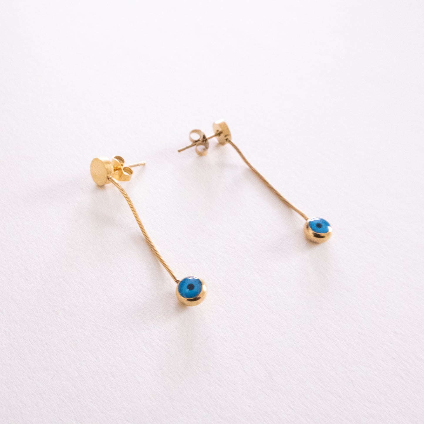 Pair of silver hoop earrings with blue and white circular designs on a white background