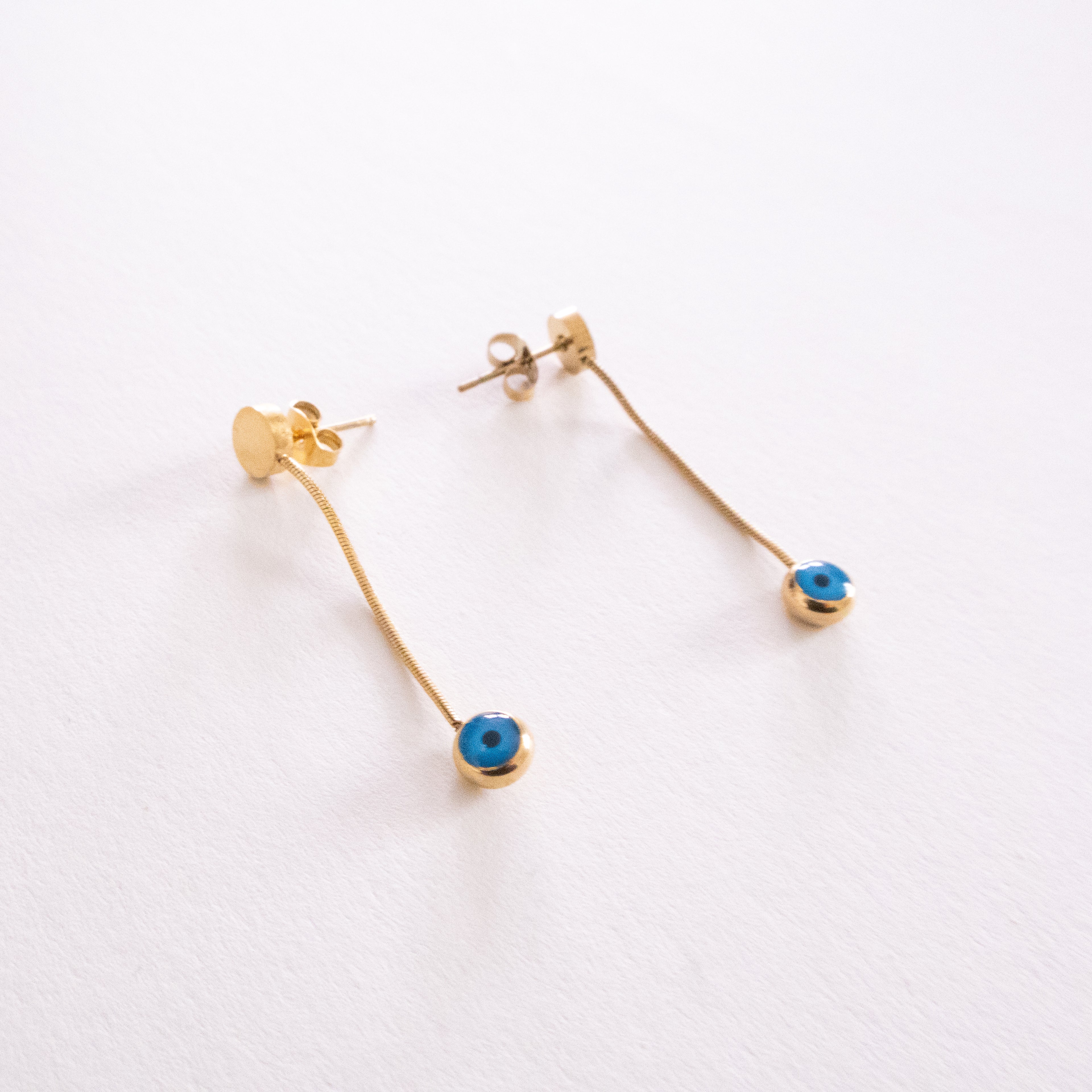 Pair of silver hoop earrings with blue and white circular designs on a white background