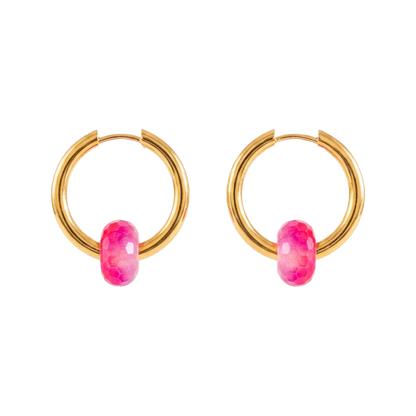 Gold hoop earrings with pink gemstones on a white background