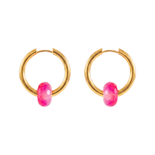 Gold hoop earrings with pink gemstones on a white background