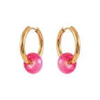 Gold hoop earrings with pink spherical charms on a white background