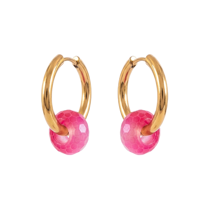 Gold hoop earrings with pink spherical charms on a white background