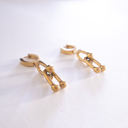 Gold chain-style earrings on a white background