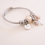 Silver bracelet with various charms on a light background