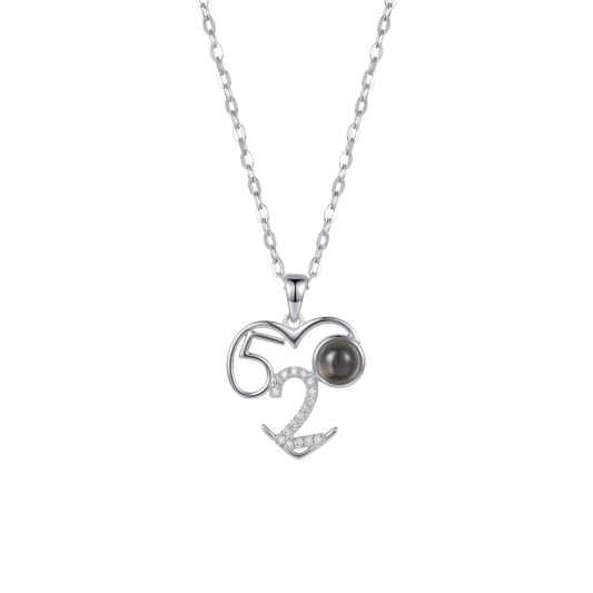 Silver necklace with a heart-shaped pendant featuring the number 52 and a black gemstone on a white background.