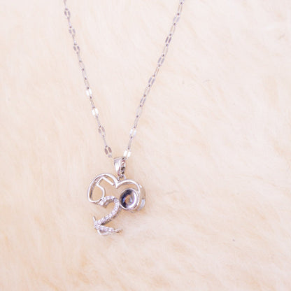 Silver necklace with a heart-shaped pendant on a beige background