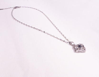 Silver necklace with a heart-shaped pendant on a white background