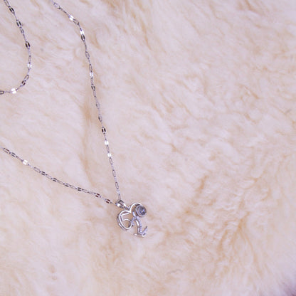Silver necklace with a heart pendant on a fluffy white surface