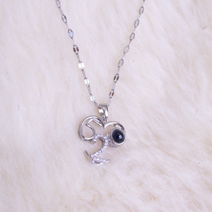 Silver necklace with a pendant featuring a black gemstone on a white fur background