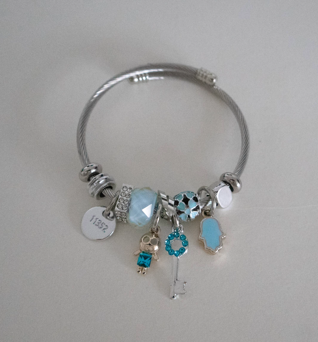 Silver bracelet with charms on a light gray background