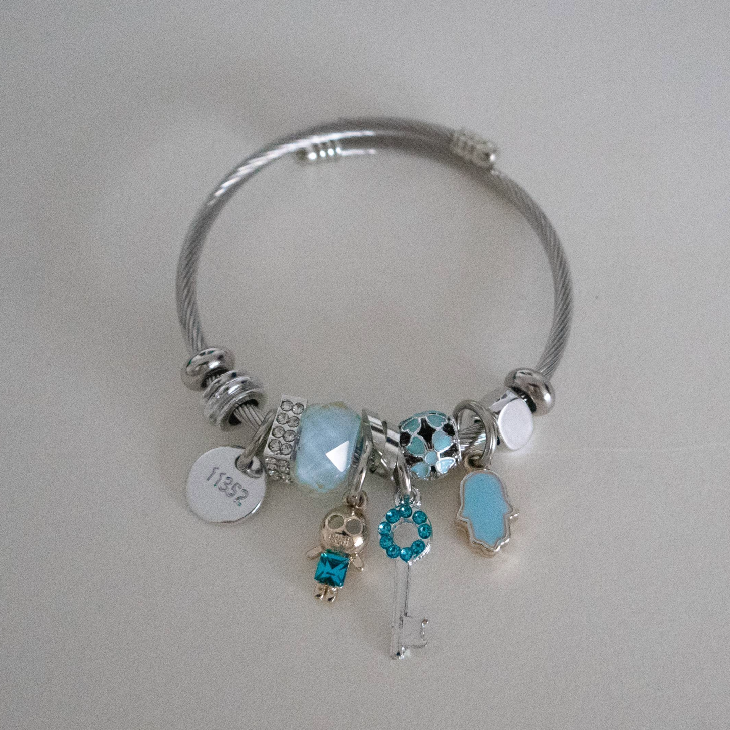 Silver bracelet with charms on a light gray background