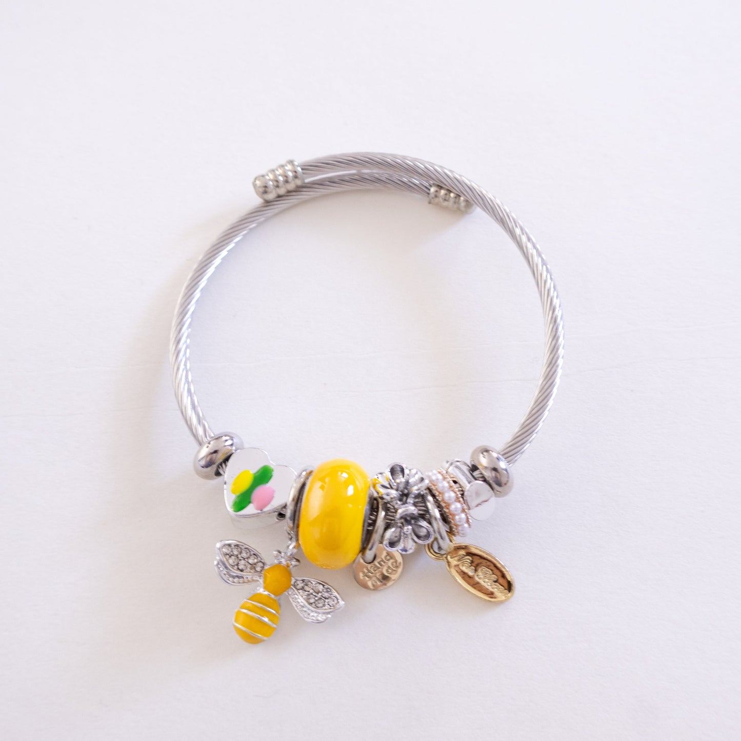 Silver bracelet with colorful charms on a white background