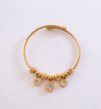 Gold bracelet with beads and crystals on a light gray background
