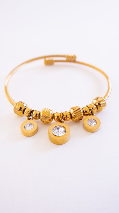 Gold bracelet with beads and crystals on a white background