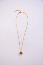 Gold necklace with a pendant on a light purple background