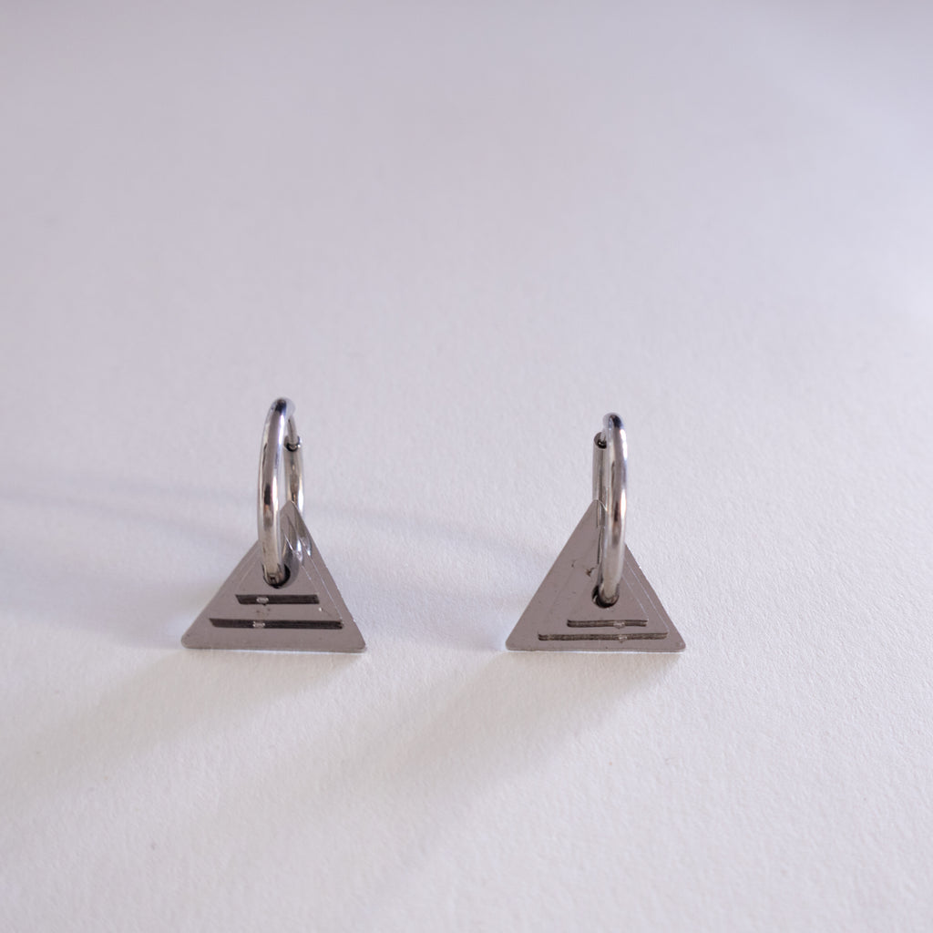 Pair of triangle-shaped earrings on a light gray background