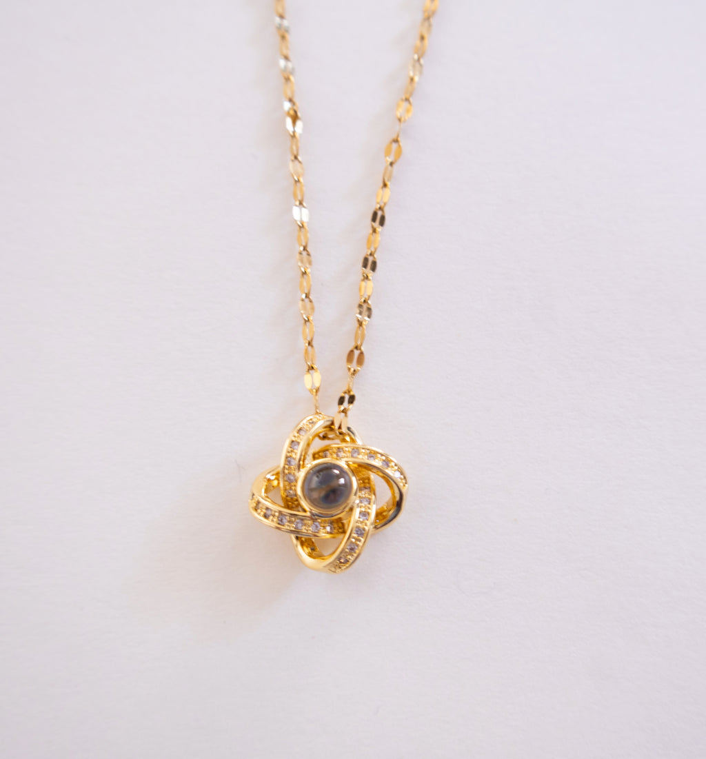 Gold necklace with a pendant on a light gray background