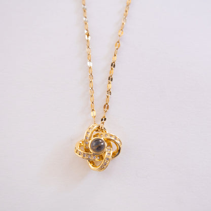 Gold necklace with a pendant on a light gray background
