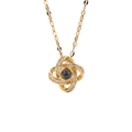 Gold necklace with a central black gemstone and diamond accents on a white background