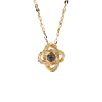Gold necklace with a central black gemstone and diamond accents on a white background