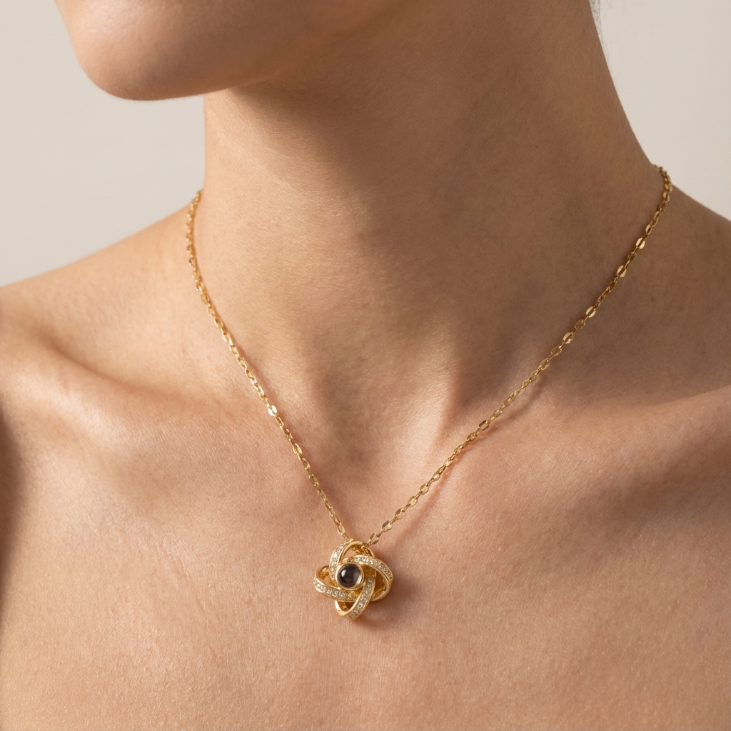 Gold necklace with a intricate pendant on a person's neck against a neutral background