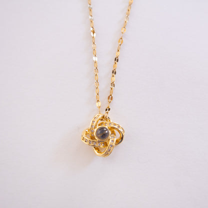 Gold necklace with a pendant on a light gray background