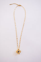 Gold necklace with a pendant on a white background