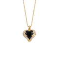 Gold necklace with a heart-shaped black gemstone pendant on a white background