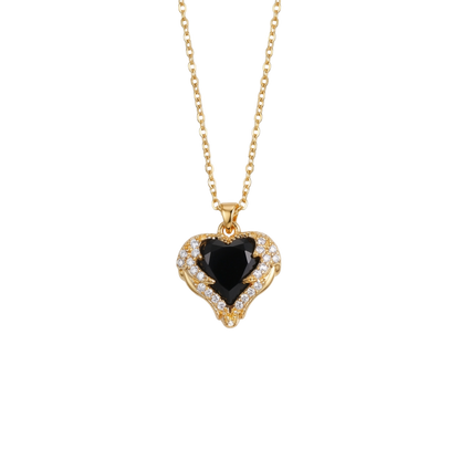 Gold necklace with a heart-shaped black gemstone pendant on a white background
